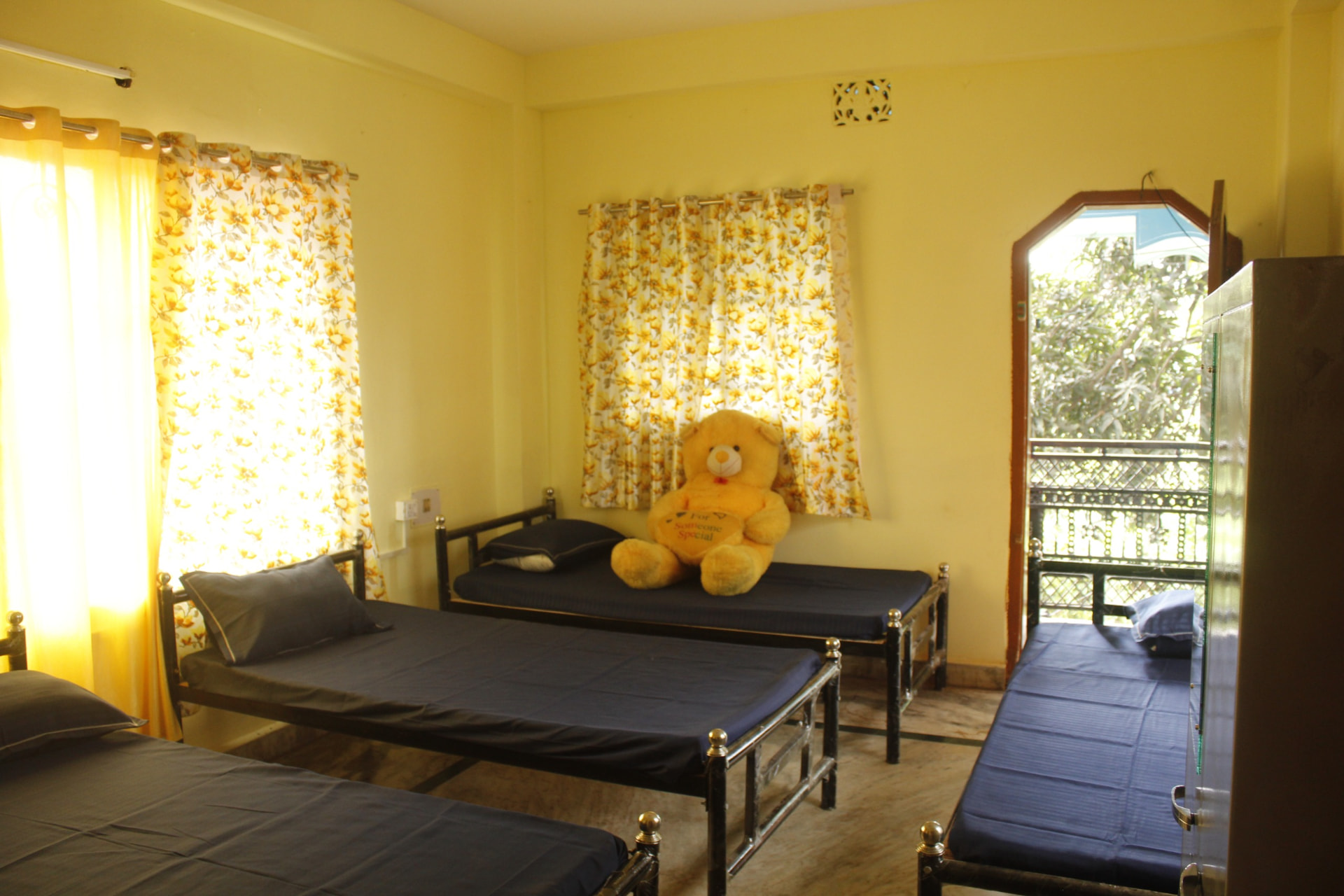 Sunlit room with beds and wardrobe at Sharma PG Home in Siliguri